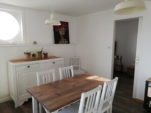 Enjoy meals in this cozy dining area with a wooden table and comfortable seating.