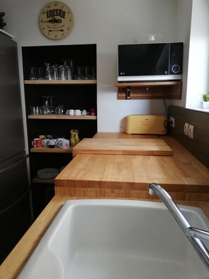 Efficient kitchen with stainless steel sink, microwave, and toaster, perfect for meal preparation.