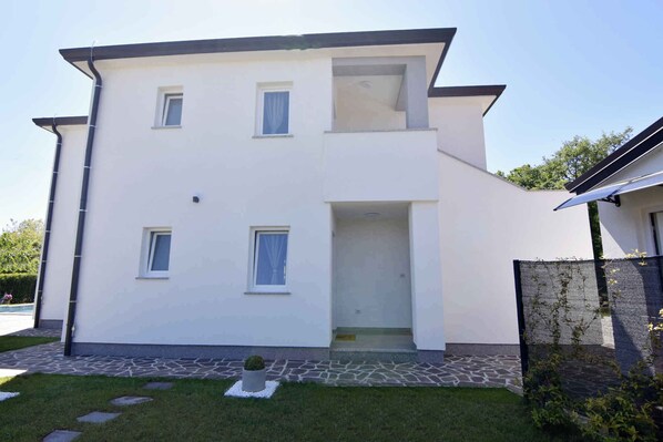 Un bâtiment moderne à deux étages, doté d’un toit plat, de murs extérieurs blancs et d’un petit balcon à l’étage supérieur.