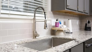 A kitchen with a granite countertop, a stainless steel faucet, and a window with blinds. - 5 mns to Sea World! Beautiful, updated 1story home with large backyard & playset (San Antonio)