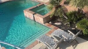 A swimming pool with a hot tub, surrounded by lounge chairs and palm trees. - Private Coastal Home w/ Pool & Hot Tub • Enclosed Garden • Near Beaches (Corpus Christi)