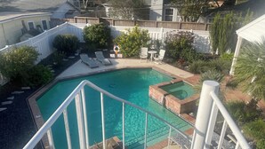 A swimming pool with a wooden deck, lounge chairs, and a small hot tub. - Private Coastal Home w/ Pool & Hot Tub • Enclosed Garden • Near Beaches (Corpus Christi)