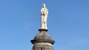 Un monumento histórico con una estatua en la parte superior, que presenta una cúpula y una entrada en arco.