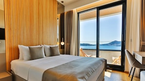 Un hotel moderno con una cama grande, un escritorio y vista al mar.