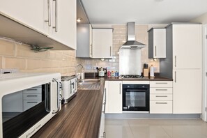 Effortlessly cook and entertain in this well-equipped kitchen with an oven, microwave, and gas stove.