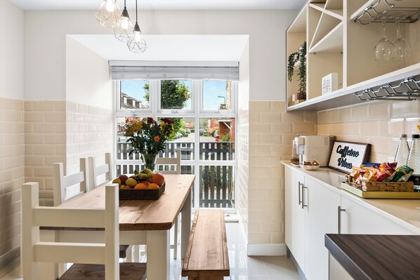 Enjoy meals in this kitchen with a dining area, wine rack, and large window offering a neighborhood view.