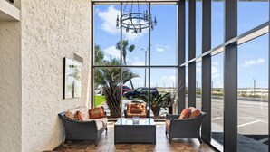 A spacious indoor area with wicker furniture, a glass coffee table, and a view of the street outside.