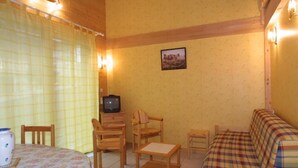 A cozy living room with a wooden table, chairs, a sofa, and a television. - Wifi, Ground floor, terrace, tv, 58m², Les Gets (Les Gets)