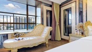 A bedroom with a large window, a bed, a vanity with a mirror, and a decorative chair. - Xinyue Theme Hotel (Longjiang Convention and Exhibition Center Shop) (Foshan)