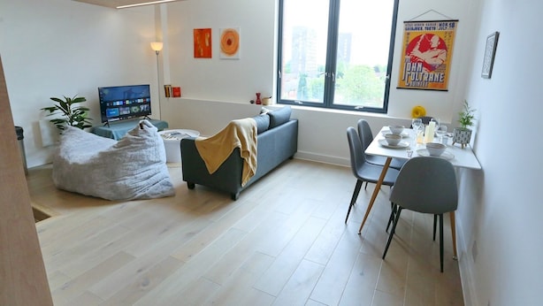 A modern living room with a sofa, a bean bag, a dining table with chairs, and a TV. - Central Trafford Duplex With Shop at Base - Pass the Keys (Manchester)