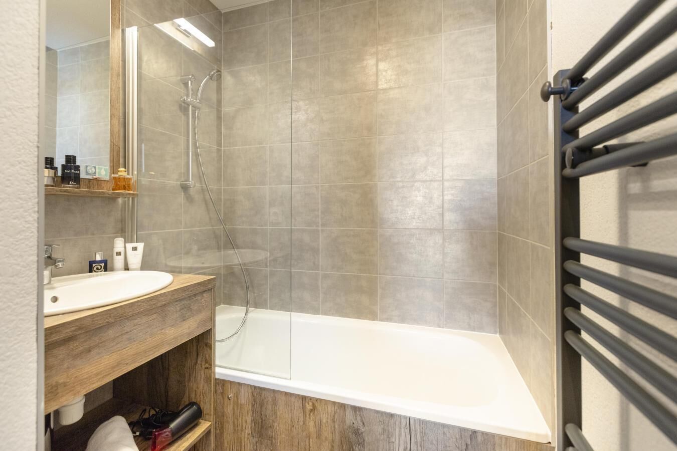 Een moderne badkamer met een douche, wastafel en badkamermeubel.