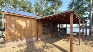 Une cabane en bois dotée d’un porche couvert et d’une allée en gravier.