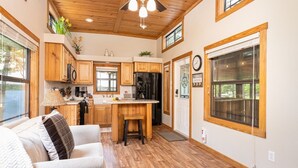 Une cuisine avec des meubles en bois, un îlot central et un coin repas comprenant un canapé.