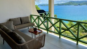 A balcony with a view of a large body of water and green hills. - Flamingo Marina Penthouse Condo (Playa Flamingo)