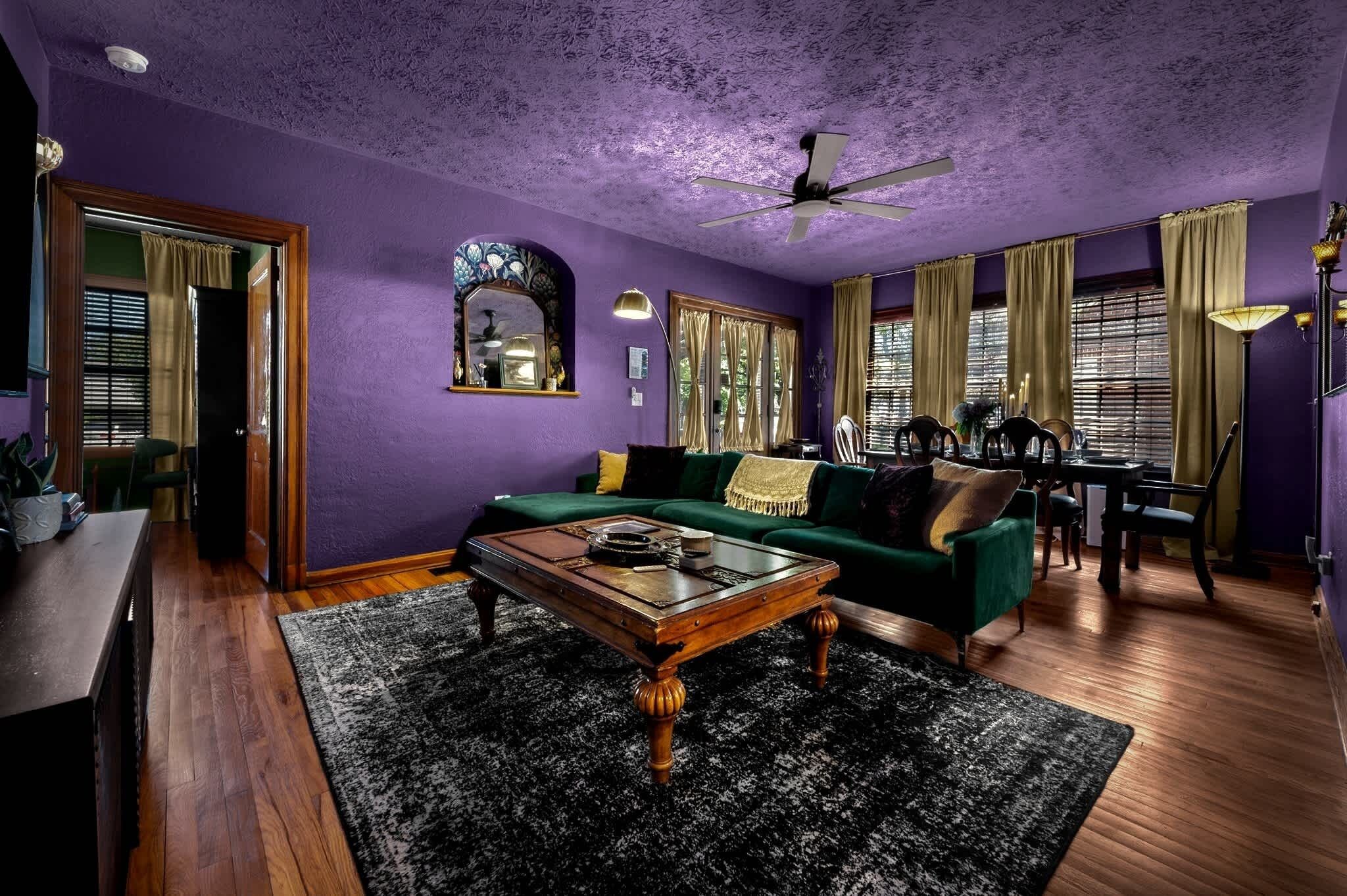 A living room with a green sofa, wooden coffee table, and a ceiling fan.
