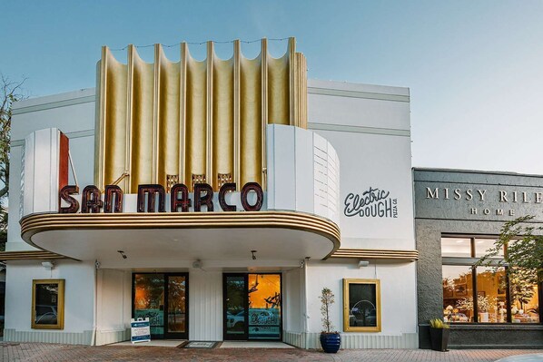 A theater with a marquee reading 'San Marco' and a sign for 'Electric Dough Pizza Co.'