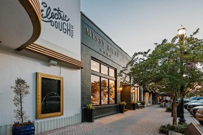 Ein Gebäude mit einem Schild, auf dem 'Missy Riley Home' und ein weiteres Schild für 'Electric Dough Pizza Co.' stehen.
