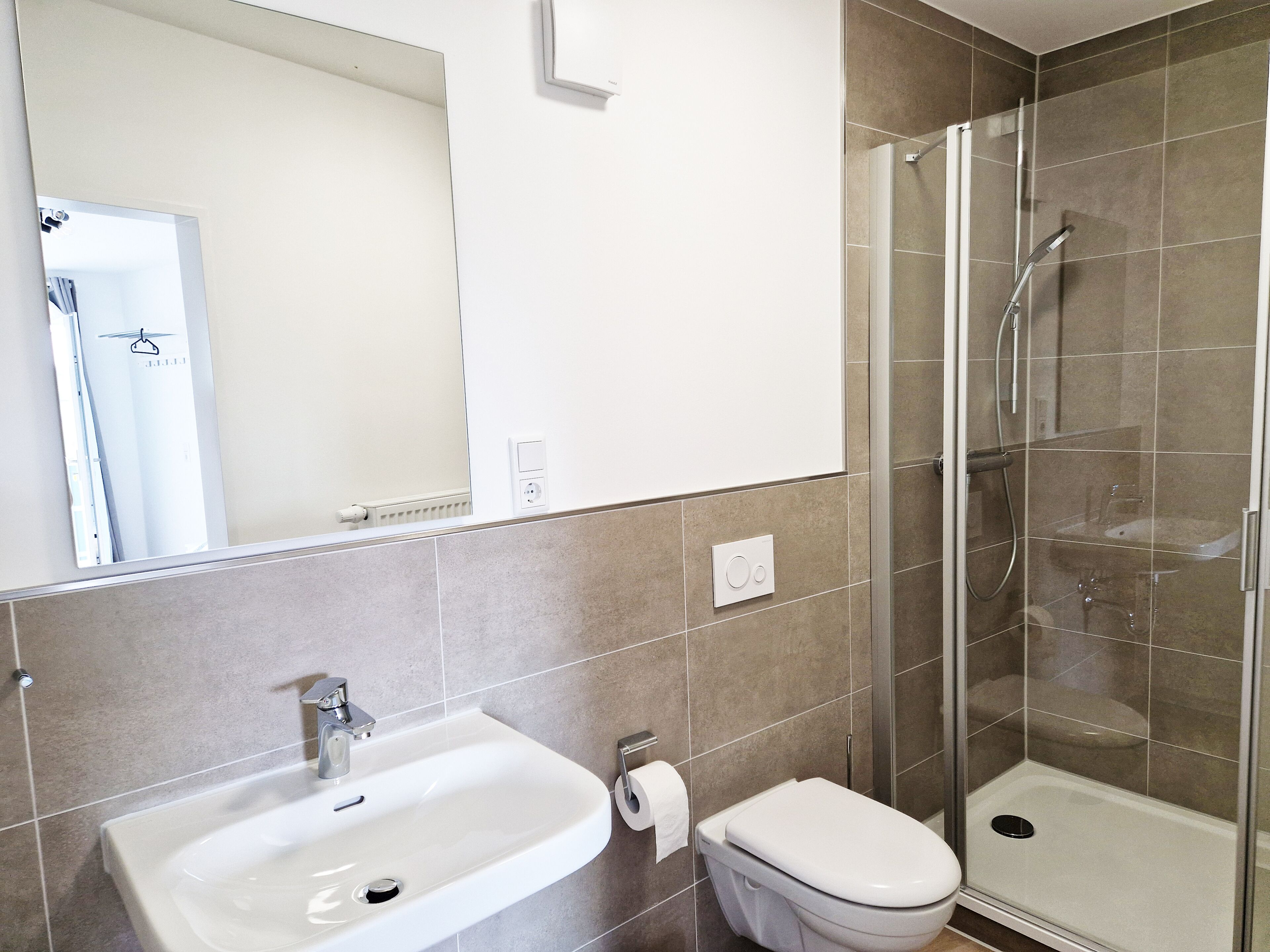 A bathroom with a sink, toilet, and glass-enclosed shower.