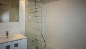 A bathroom with a glass shower enclosure, a white sink, and a mirror above the sink. - 100m from resort center, 1st floor, view valley, tv, ski locker, 20m², Les Orres (Les Orres)
