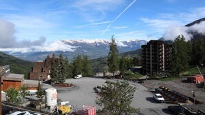 Une ville de montagne dotée d’un parking, de bâtiments et offrant une vue sur des sommets enneigés.