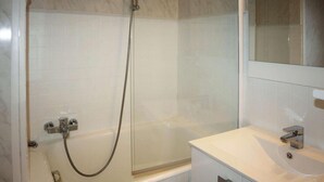 A bathroom with a glass-enclosed shower, a white sink, and a mirror above the sink. - 100m from resort center, 4th floor, tv, ski locker, 20m², Les Orres (Les Orres)