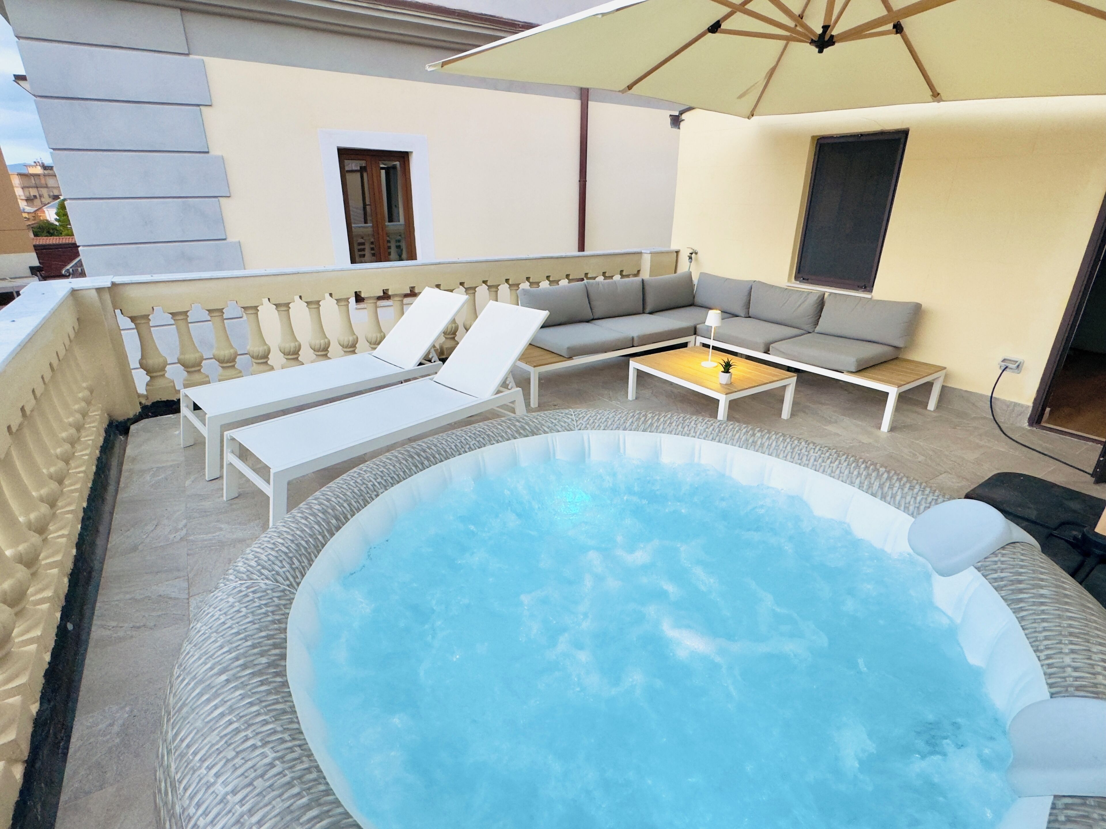Ein Poolbereich mit Whirlpool, einer Sitzecke und einem Tisch.
