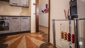 Cuina moderna amb armaris grisenys, un vàter d'acer inoxidable i una cafetera.