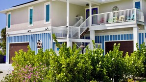 Une maison à deux étages avec un balcon, un garage et une véranda.