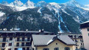 A mountain resort with snow-covered peaks and a ski slope.