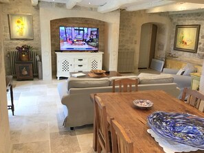 Relax in this cozy living space with a sofa, dining table, and flat-screen TV.