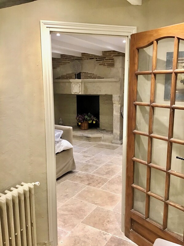 A room with a fireplace, a radiator, and a door with a glass panel. - Luxury House In A Beautiful Setting (Montayral)