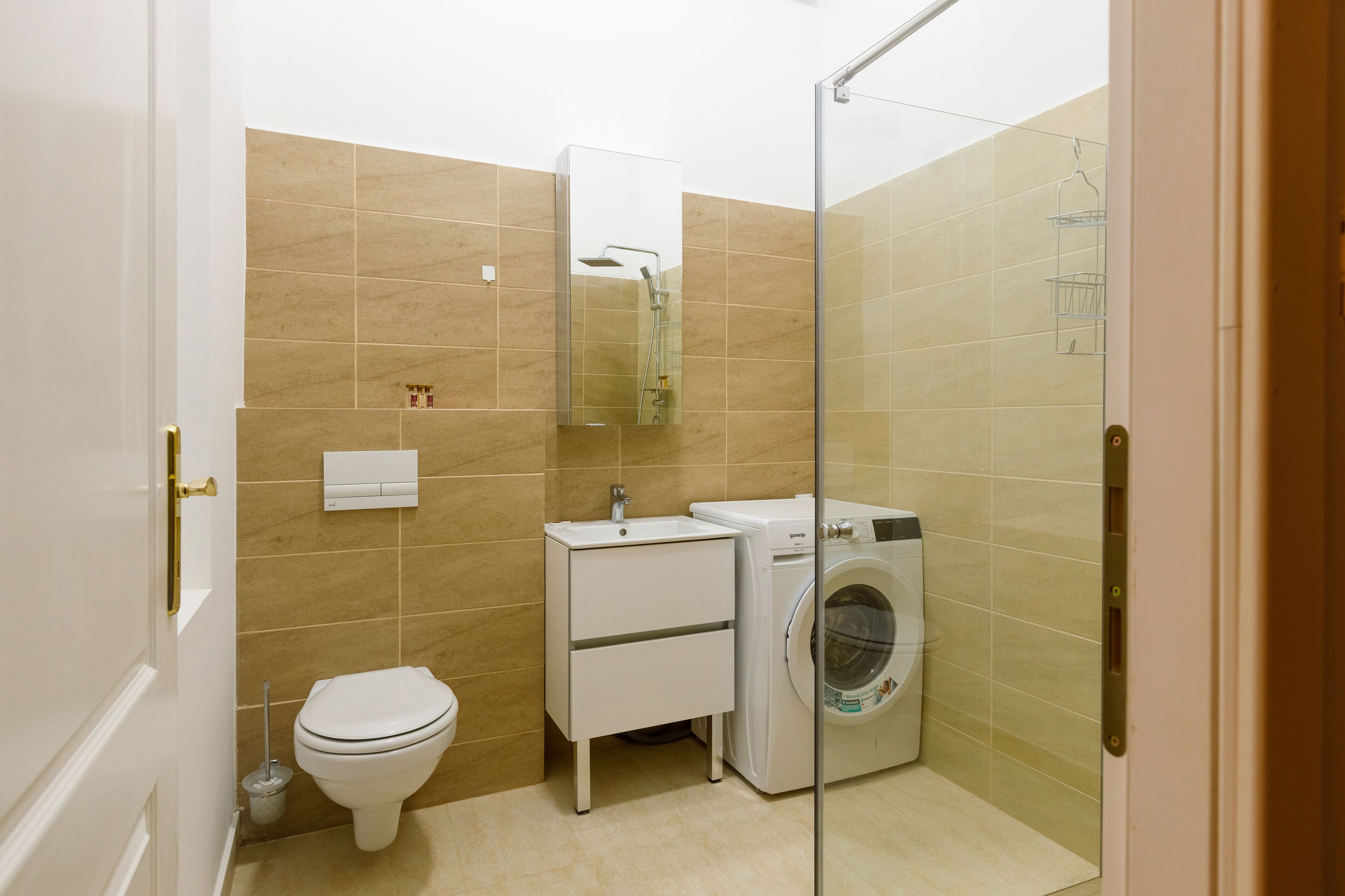 A compact bathroom with a toilet, sink, and washing machine.