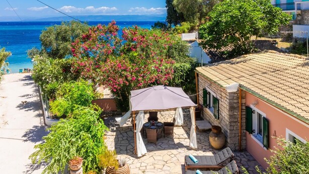 Un patio con mobiliario exterior, una mesa y una carpa.