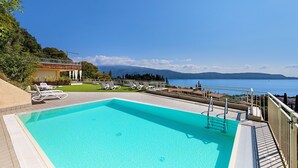 Una piscina con vistas al mar y a las montañas.