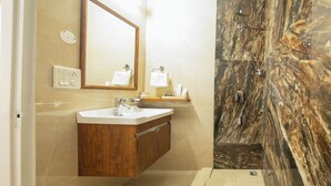 A modern bathroom with a marble vanity, a large mirror, and a wooden shower enclosure. - Firebrick Garnet House (Gurugram)