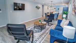 A modern living room with a blue sofa, a coffee table, and a ceiling fan.