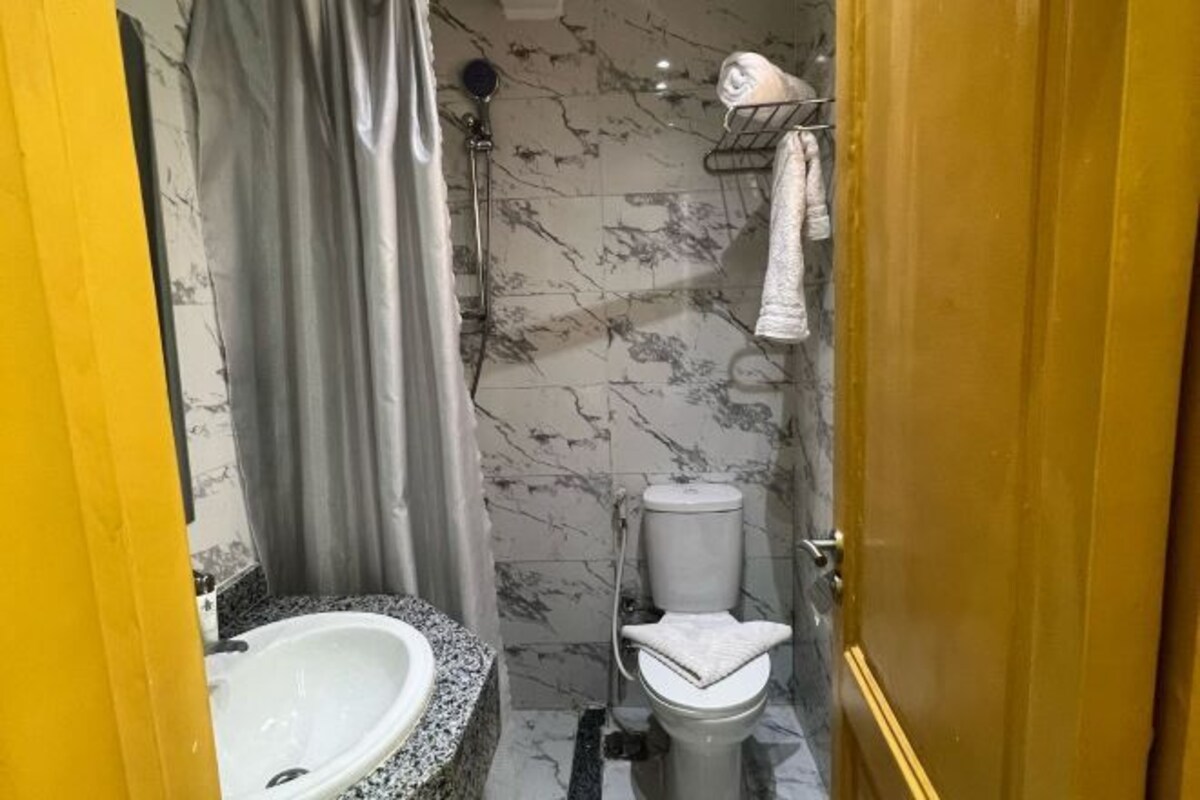 A bathroom with a marble sink, toilet, and shower.