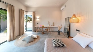 Una camera d'albergo moderna con un letto, una scrivania e un angolo ristoro.
