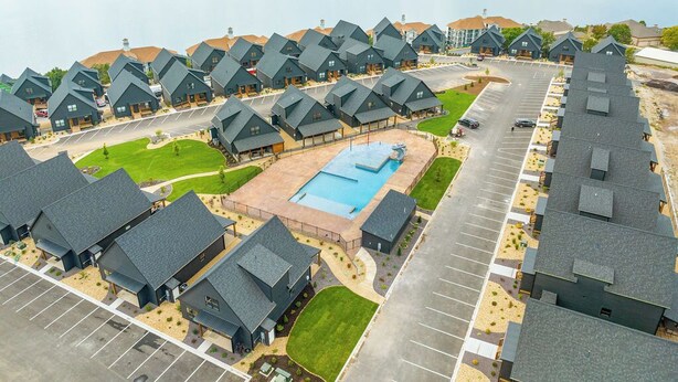Un barrio residencial con varias casas, una piscina y un estacionamiento.