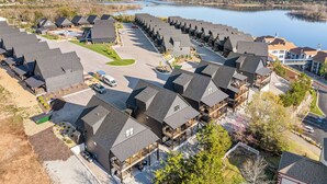 Zona residencial con varias casas, un estacionamiento y un lago al fondo.