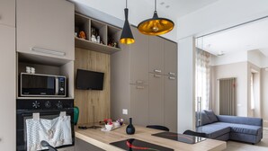 Eine moderne Küche mit eingebauter Mikrowelle, Backofen und Flachbildfernseher.