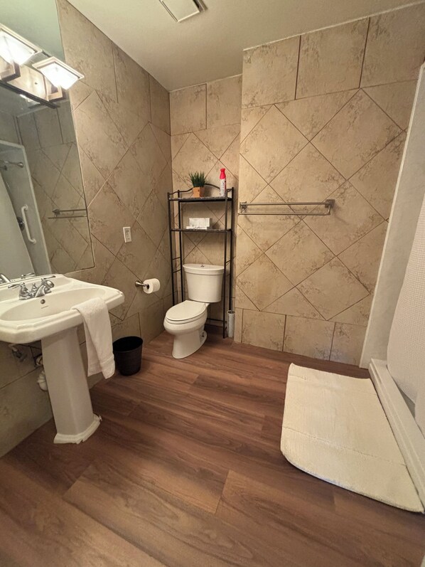 A bathroom with a sink, toilet, and shower.