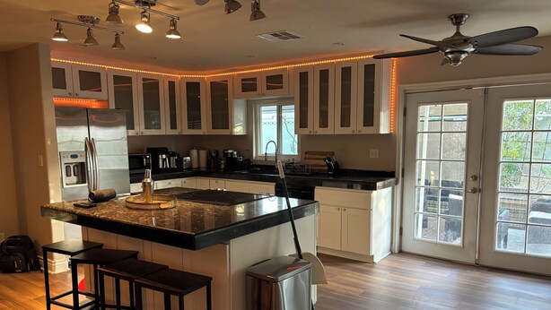A modern kitchen with a large island, stainless steel appliances, and pendant lighting. - Stylish house with pool close to strip (Las Vegas)