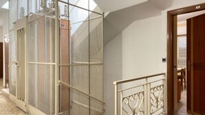 A corridor with a glass partition, a metal railing, and a door leading to a room. - Appartamento sul Lungomare by Tempovacanza (Marina di Andora)