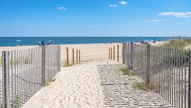 A sandy beach path leading to the sea, flanked by wooden fences. - Oceanfront Studio-Sleeps4-Linens Incl-WiFi-Kitchen (Ocean City)