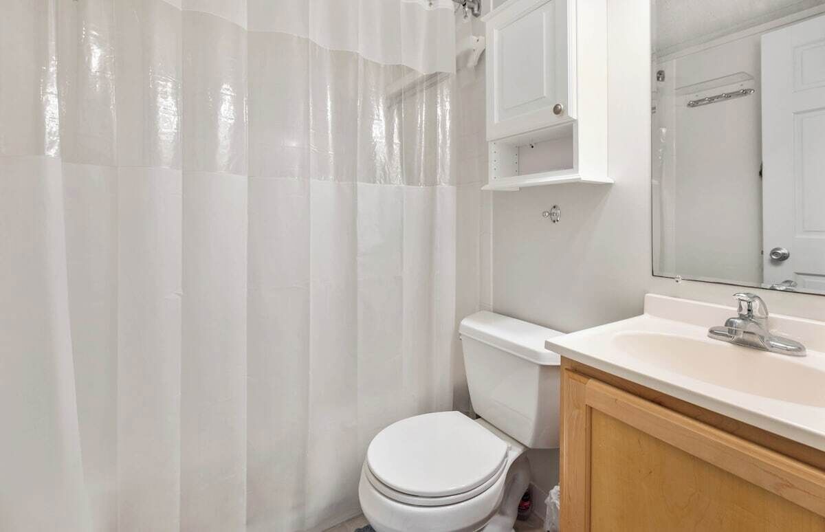 Une salle de bain avec des toilettes, un lavabo et un miroir.