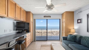 A compact living space with a kitchen, a dining area, a sofa, and a balcony with a view of the beach. - Oceanfront Studio-Sleeps4-Linens Incl-WiFi-Kitchen (Ocean City)