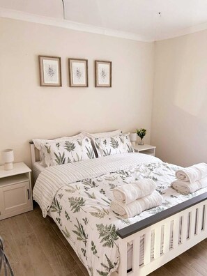2 dormitorios, tabla de planchar con plancha, ropa de cama