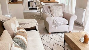 Ein gemütliches Wohnzimmer mit einer Couch, einem Couchtisch und einem Essbereich mit Tisch und Stühlen.