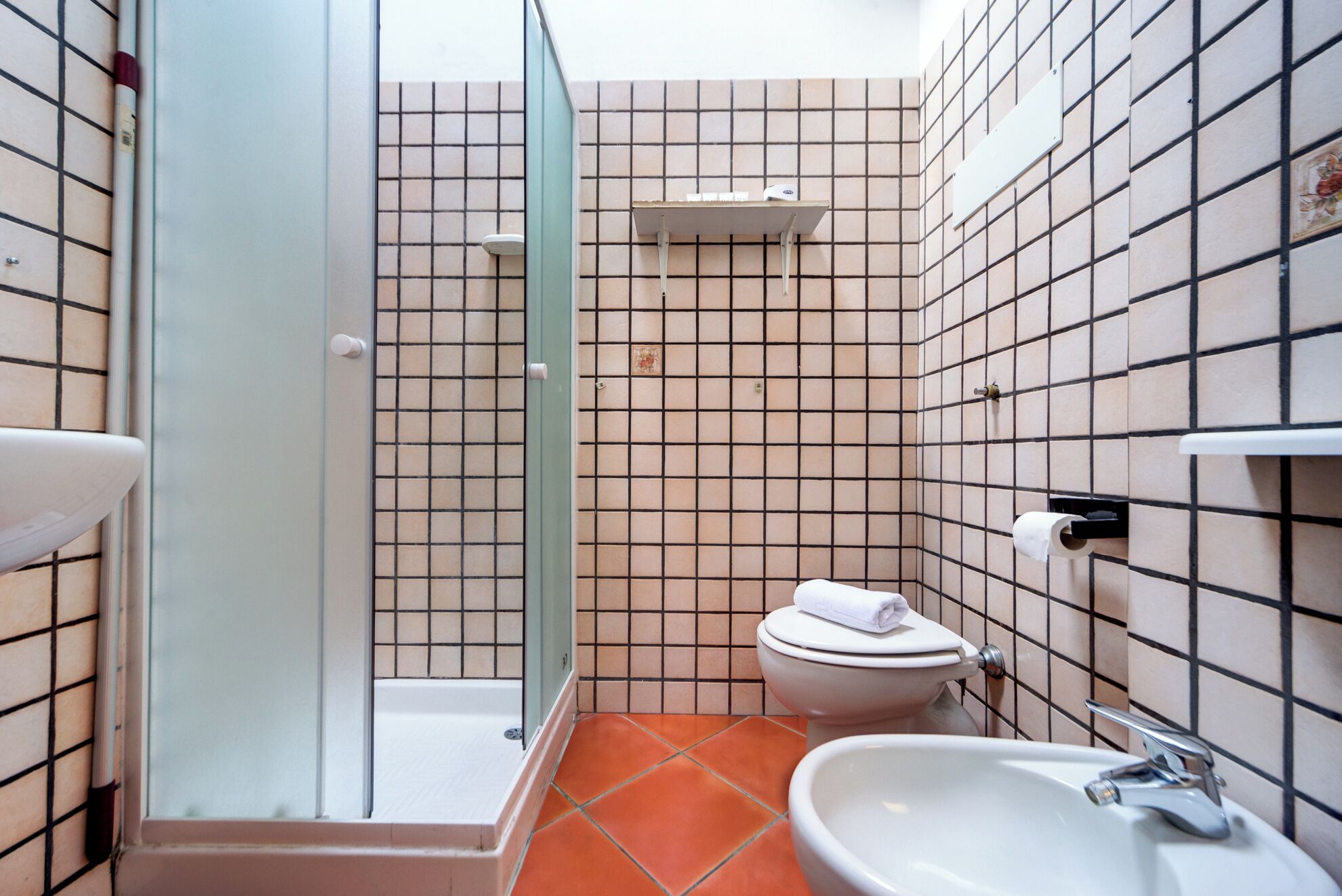 Un baño pequeño con inodoro, lavabo y zona de ducha.